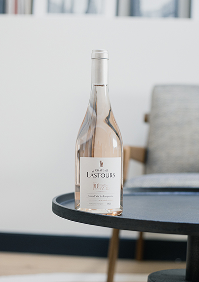 Bouteille de vin rosé Château de Lastours posée sur une table basse dans un intérieur contemporain