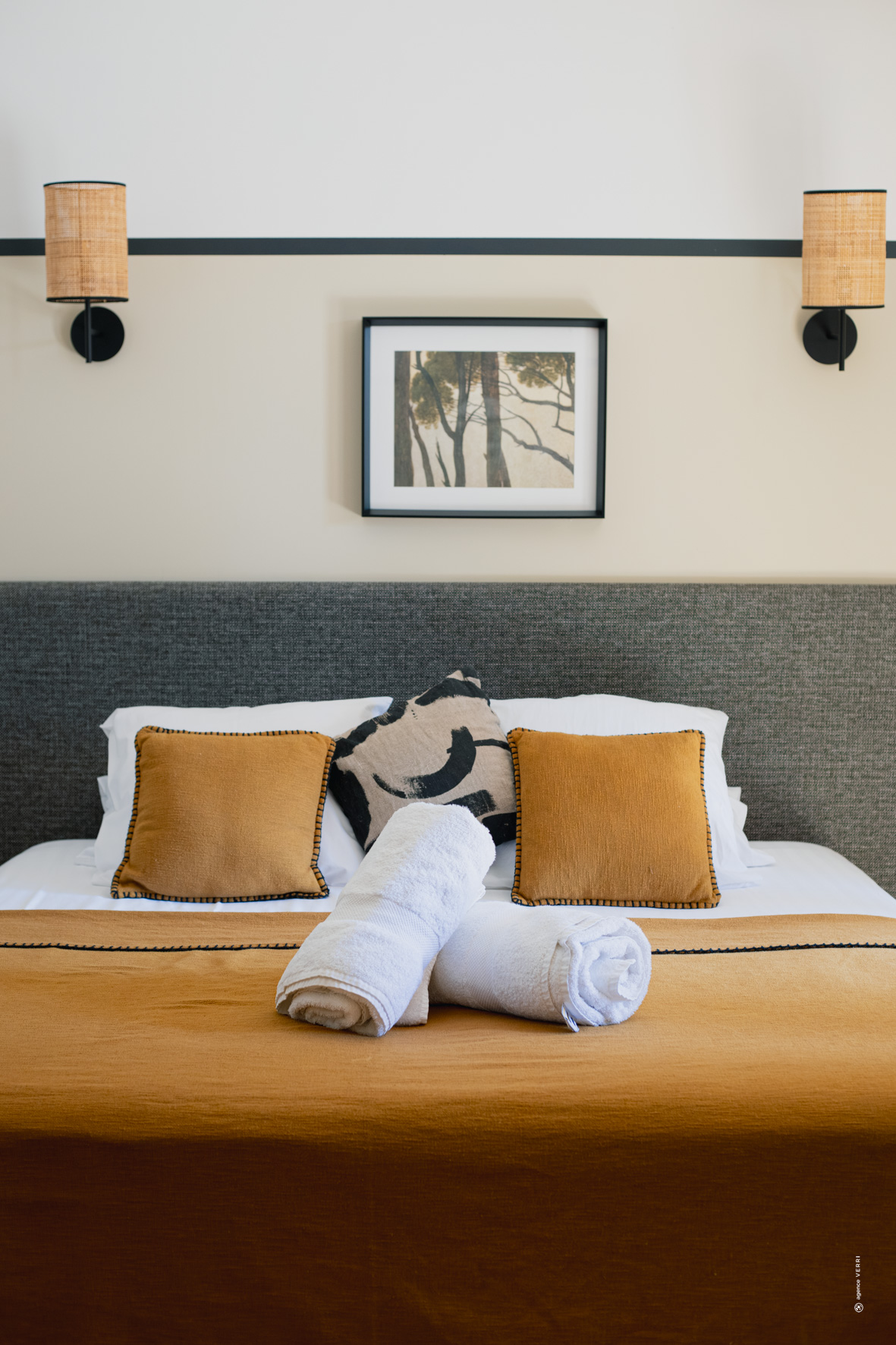 Chambre avec lit double, linge de bain roulé et décoration élégante