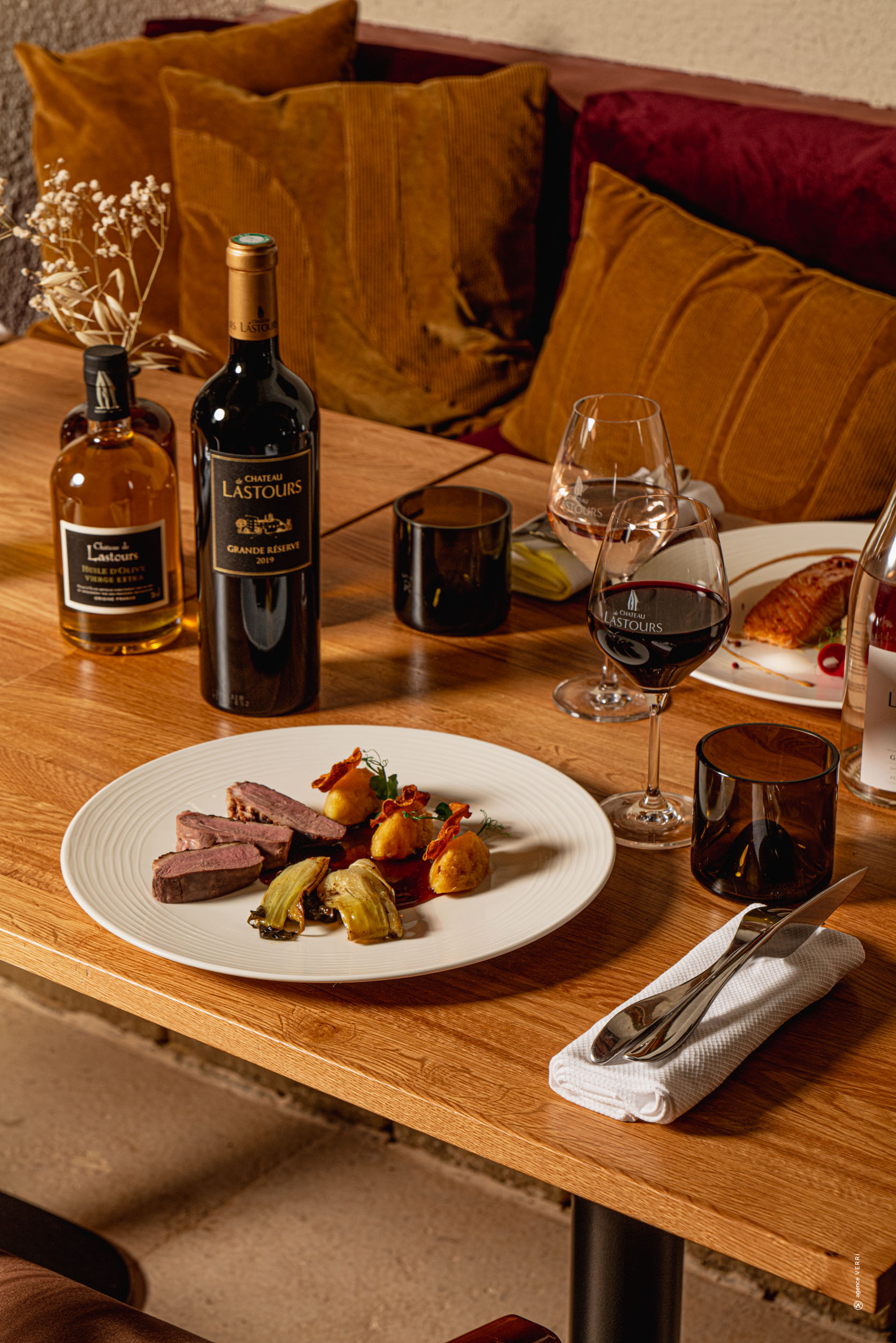 Assiette de magret de canard accompagné de légumes et purée, servie avec vin rouge Château de Lastours