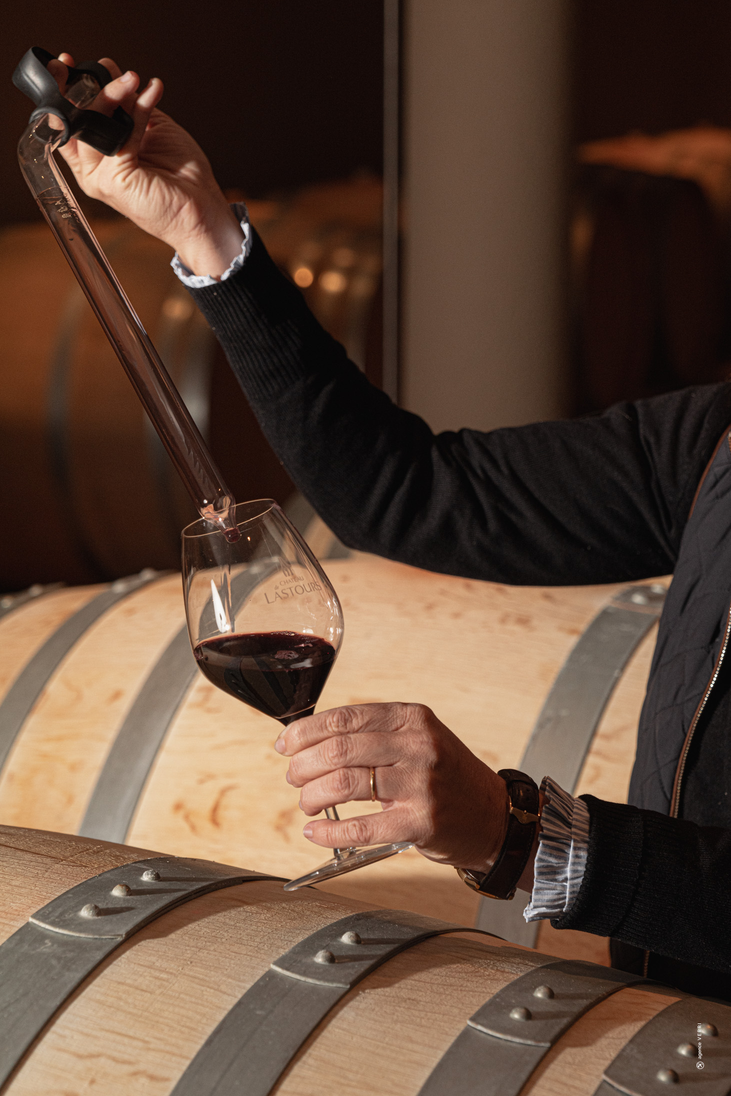 Dégustation de vin en barrique au Château de Lastours – prélèvement avec pipette dans un verre gravé