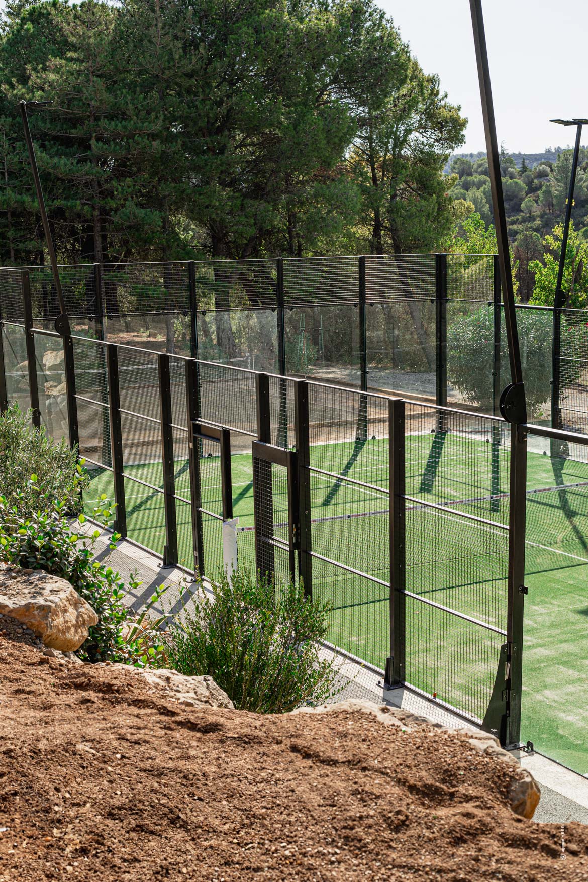 Terrain de padel extérieur au Château de Lastours entouré de nature méditerranéenne