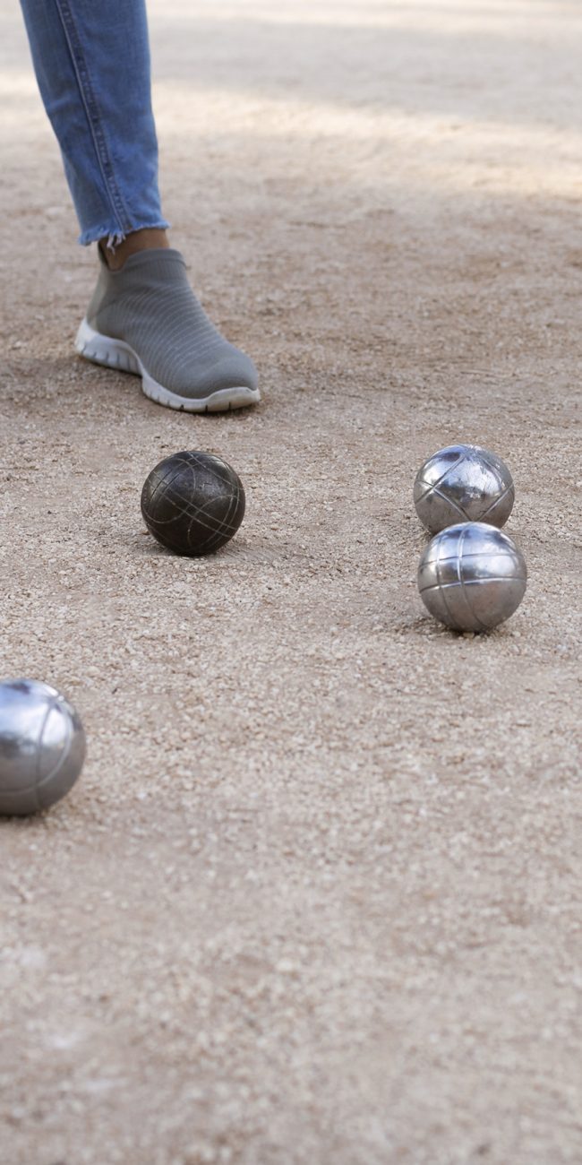 Partie de pétanque au Château de Lastours – boules en métal et cochonnet sur terrain sablé