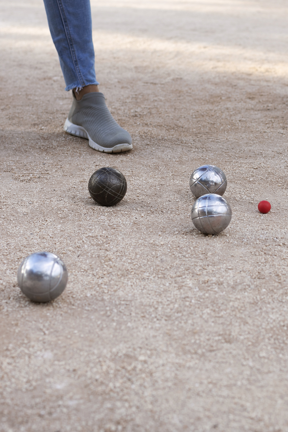 Partie de pétanque au Château de Lastours – boules en métal et cochonnet sur terrain sablé