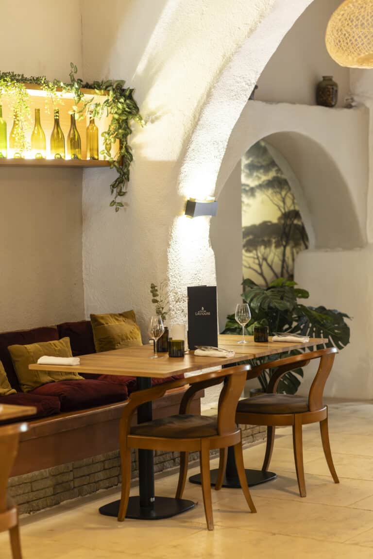 Table élégamment dressée au restaurant du Château de Lastours avec vin blanc et plat gastronomique