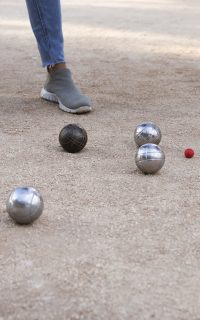 Partie de pétanque au Château de Lastours – boules en métal et cochonnet sur terrain sablé